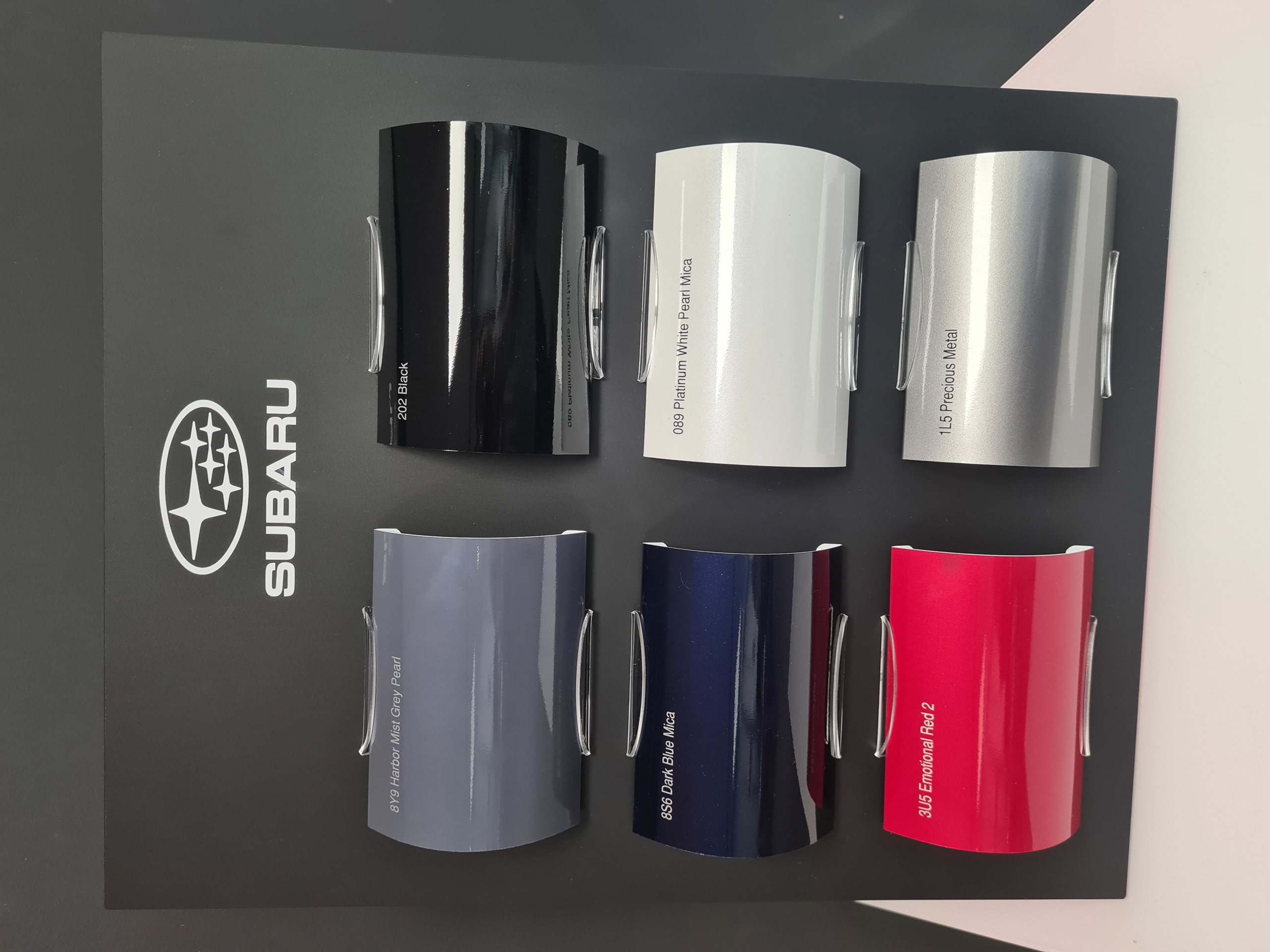 Bildet viser et lite stativ med fargekart til bilfarger for Subaru